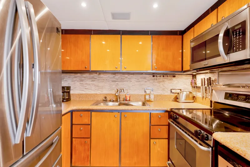 Marvelous Yacht Photos Pics Luxurious kitchen in a 1999 Cheoy Lee 74 yacht with modern appliances and wood cabinetry.