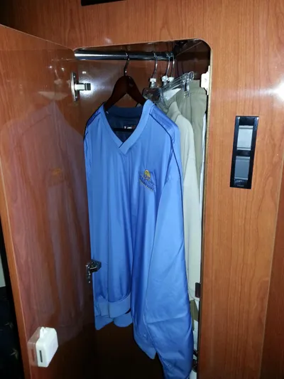 Johnny B Good Yacht Photos Pics Wooden closet in 2007 Regal Commodore 4060 yacht with blue jacket and beige pants.