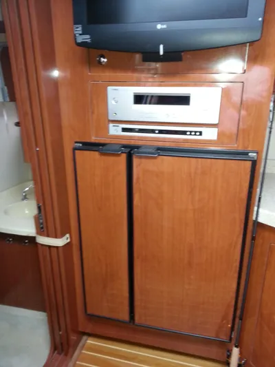 Johnny B Good Yacht Photos Pics 2007 Regal Commodore 4060 yacht interior with wood paneling, TV, and built-in appliances.