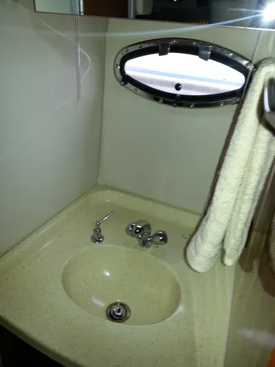 Johnny B Good Yacht Photos Pics 2007 Regal Commodore 4060 bathroom sink with towel and porthole window.