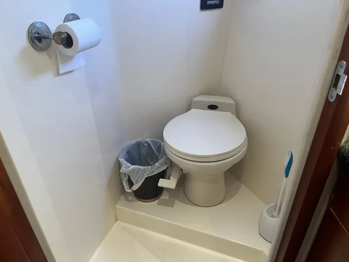  Yacht Photos Pics 1999 Carver 530 Voyager Pilothouse bathroom with toilet, trash can, and toilet brush.