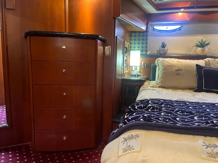  Yacht Photos Pics Luxurious 1999 Carver 530 Voyager Pilothouse bedroom with elegant wood cabinetry and cozy bedding.