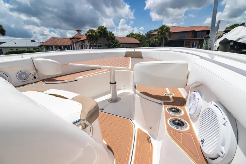  Yacht Photos Pics 2016 Edgewater 368CC boat interior with seating, table, and speakers under a cloudy sky.