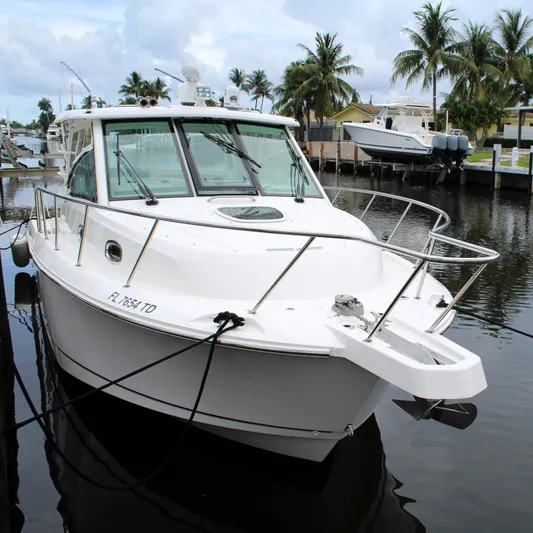 F-troop Yacht Photos Pics 2017 Boston Whaler 345 Conquest boat docked in a marina with palm trees.