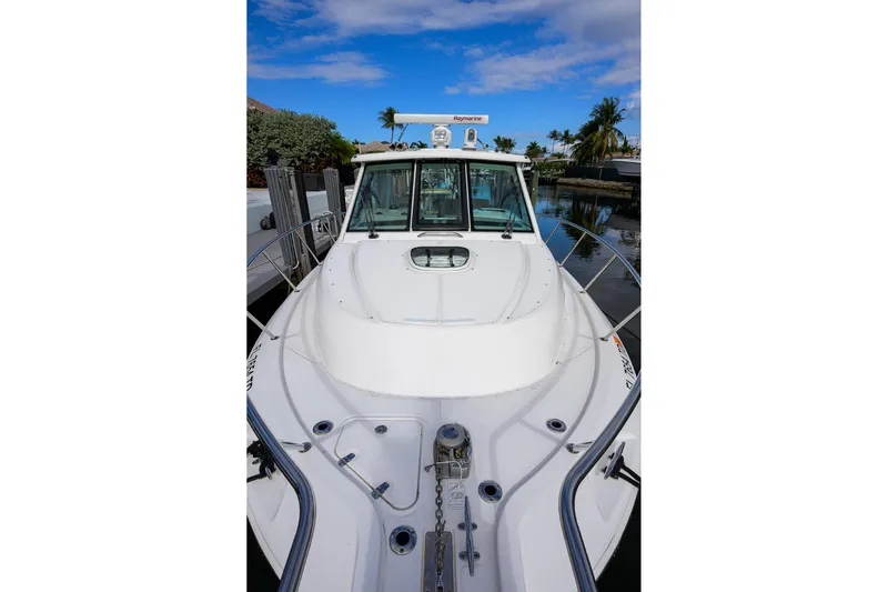 F-troop Yacht Photos Pics 2017 Boston Whaler 345 Conquest boat docked by palm trees under blue sky.
