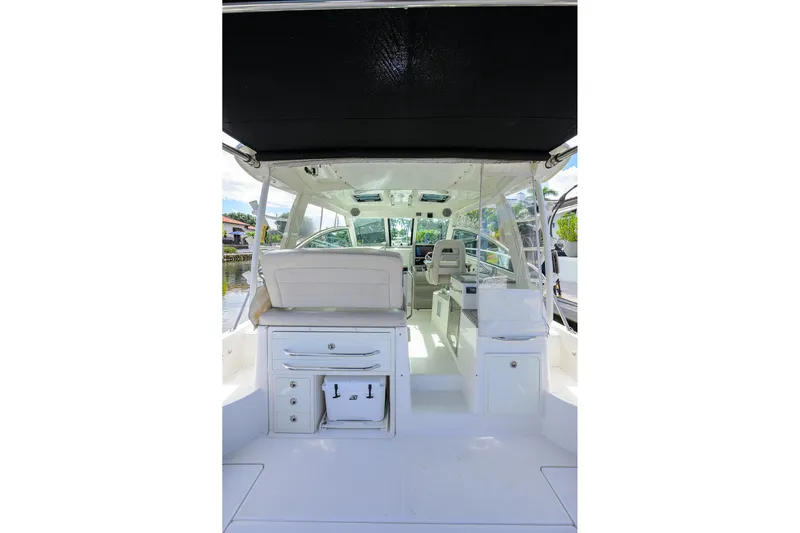 F-troop Yacht Photos Pics 2017 Boston Whaler 345 Conquest interior with seating and storage, under a black canopy.