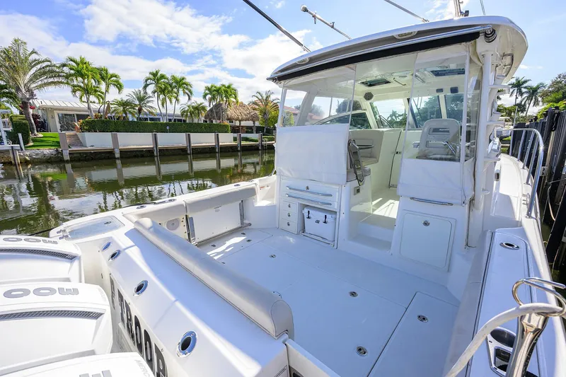 F-troop Yacht Photos Pics 2017 Boston Whaler 345 Conquest boat docked by a scenic waterfront with palm trees.