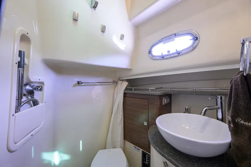 F-troop Yacht Photos Pics 2017 Boston Whaler 345 Conquest bathroom with modern sink, shower, and porthole window.