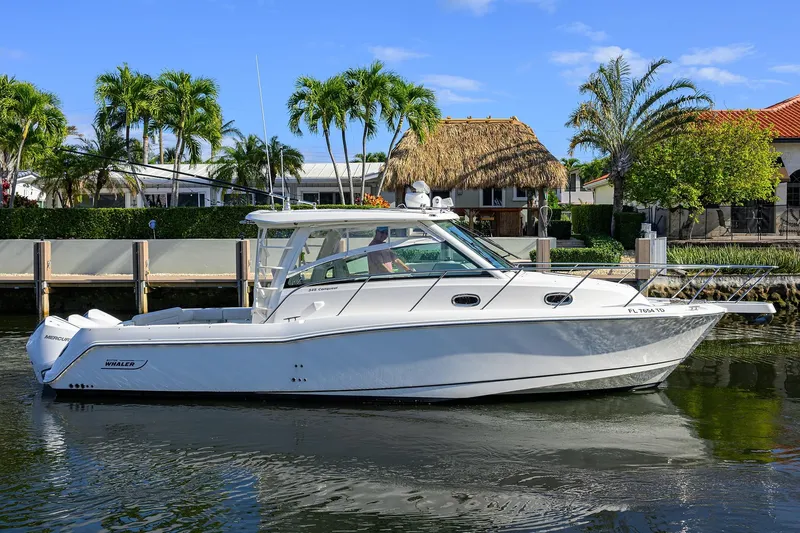 F-troop Yacht Photos Pics 2017 Boston Whaler 345 Conquest boat docked near tropical waterfront homes.