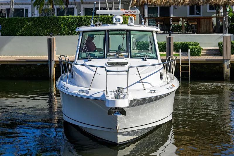 F-troop Yacht Photos Pics 2017 Boston Whaler 345 Conquest boat docked in a serene waterfront setting.