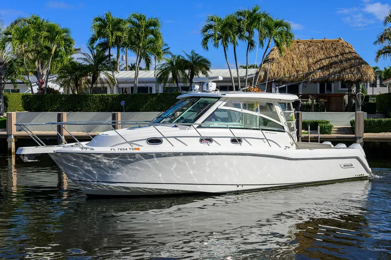 F-troop Yacht Photos Pics 2017 Boston Whaler 345 Conquest boat docked near tropical waterfront homes.