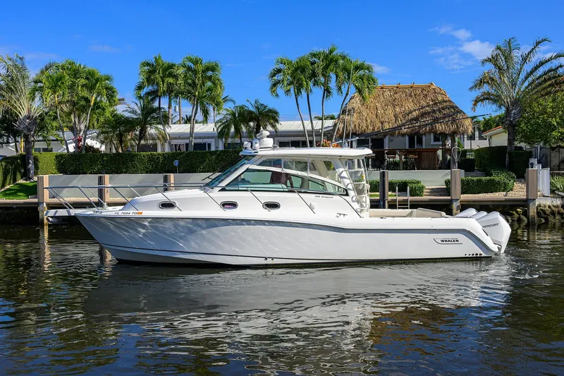 F-troop Yacht Photos Pics 2017 Boston Whaler 345 Conquest boat on calm water, surrounded by tropical scenery.