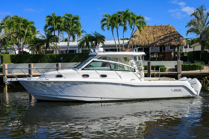 F-troop Yacht Photos Pics 2017 Boston Whaler 345 Conquest boat docked near tropical waterfront home.