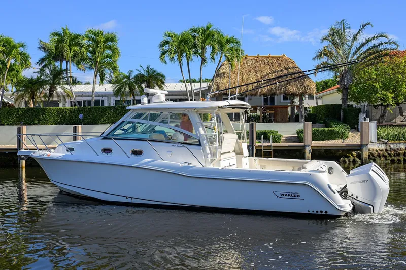 F-troop Yacht Photos Pics 2017 Boston Whaler 345 Conquest boat cruising near tropical waterfront homes.