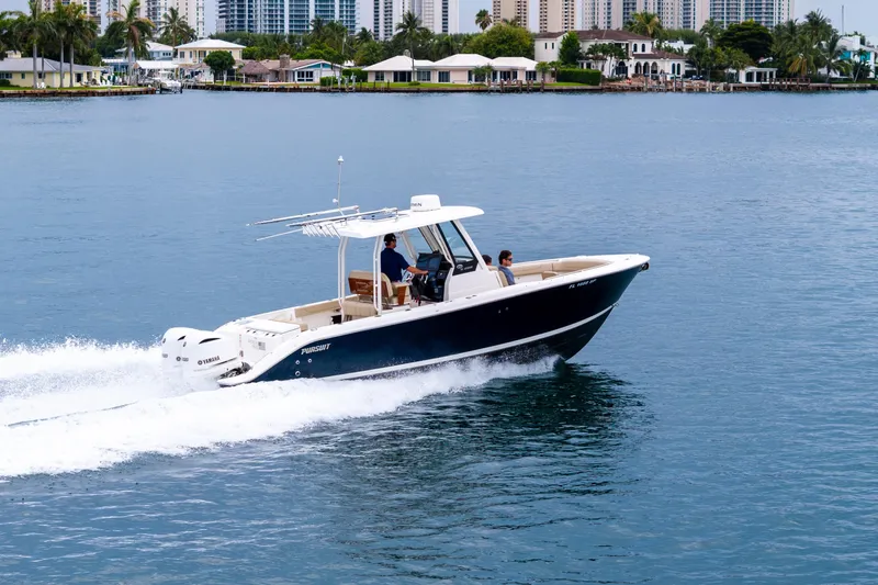 Little Perspective Yacht Photos Pics 2019 Pursuit S 288 Sport boat cruising on calm water near coastal homes.