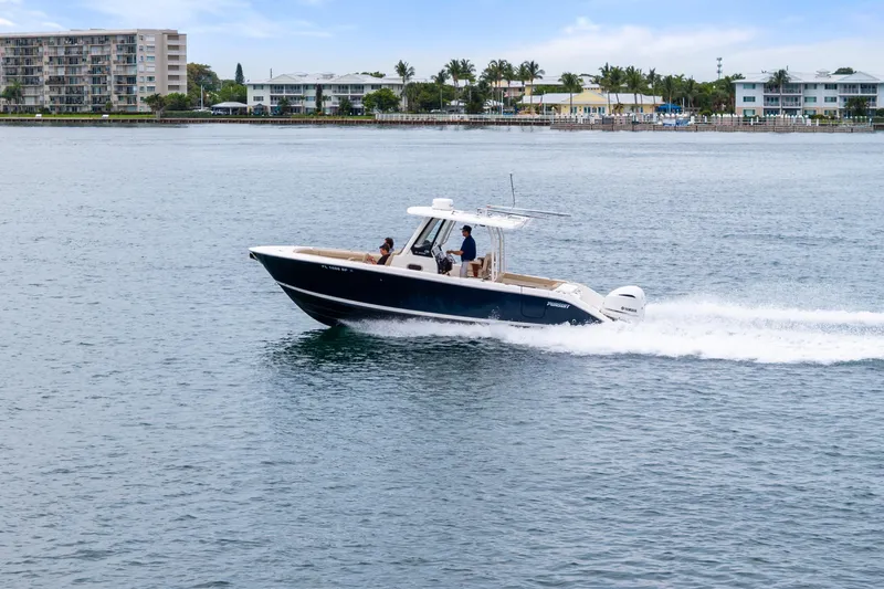 Little Perspective Yacht Photos Pics 2019 Pursuit S 288 Sport boat cruising on calm waters near coastal buildings.