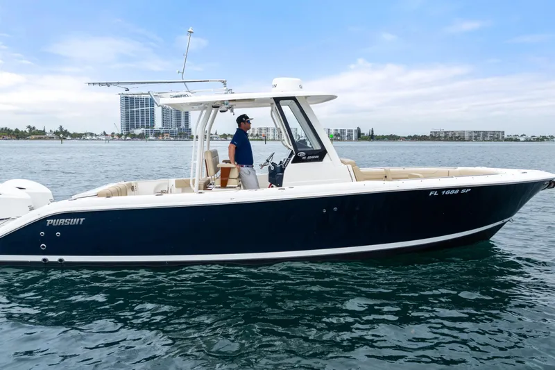 Little Perspective Yacht Photos Pics 2019 Pursuit S 288 Sport boat on water, with city skyline in background.