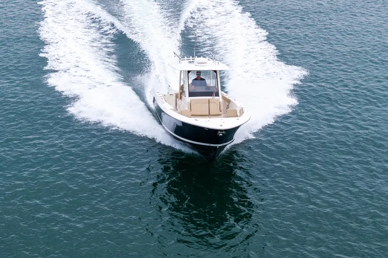 Little Perspective Yacht Photos Pics 2019 Pursuit S 288 Sport boat cruising on open water, creating a wake.