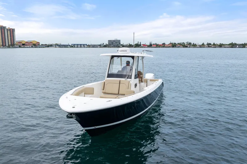 Little Perspective Yacht Photos Pics 2019 Pursuit S 288 Sport boat on calm water with cityscape background.