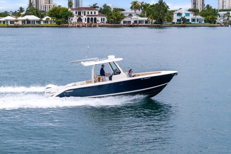 Little Perspective Yacht Photos Pics 2019 Pursuit S 288 Sport boat cruising on a calm waterway near luxury homes.