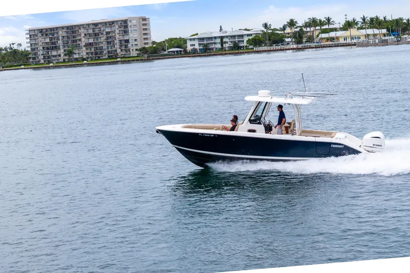Little Perspective Yacht Photos Pics 2019 Pursuit S 288 Sport boat cruising on water near coastal buildings.