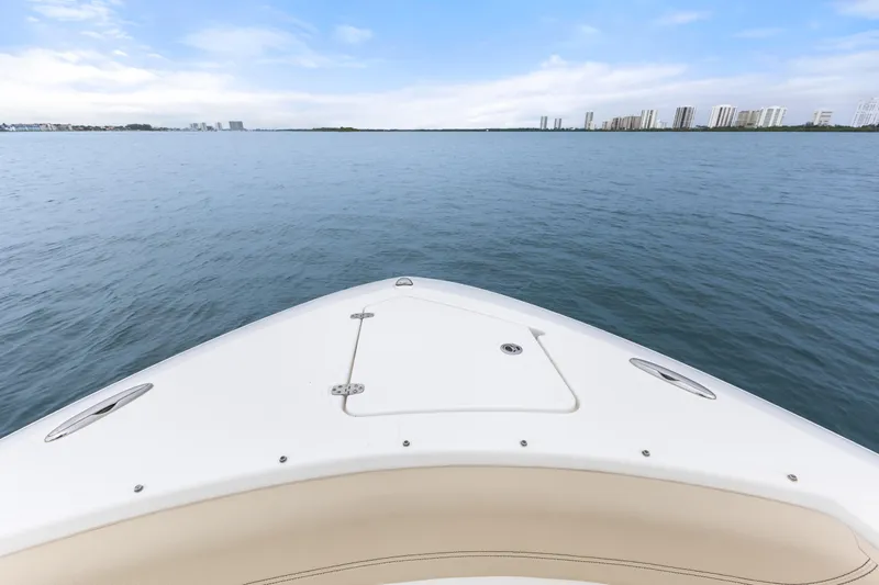 Little Perspective Yacht Photos Pics Bow view of 2019 Pursuit S 288 Sport boat on calm water with city skyline.
