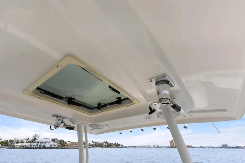 Little Perspective Yacht Photos Pics 2019 Pursuit S 288 Sport boat roof with hatch and support poles, overlooking waterfront.