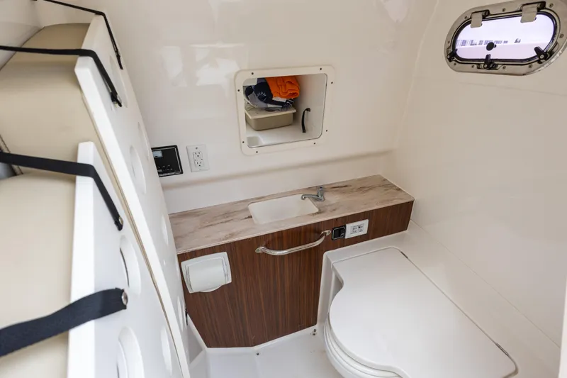 Little Perspective Yacht Photos Pics 2019 Pursuit S 288 Sport boat interior with sink, storage, and porthole window.