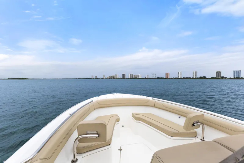 Little Perspective Yacht Photos Pics 2019 Pursuit S 288 Sport boat on calm water with city skyline in background.