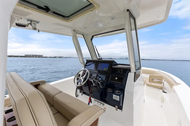 Little Perspective Yacht Photos Pics 2019 Pursuit S 288 Sport boat interior with helm, seating, and ocean view.