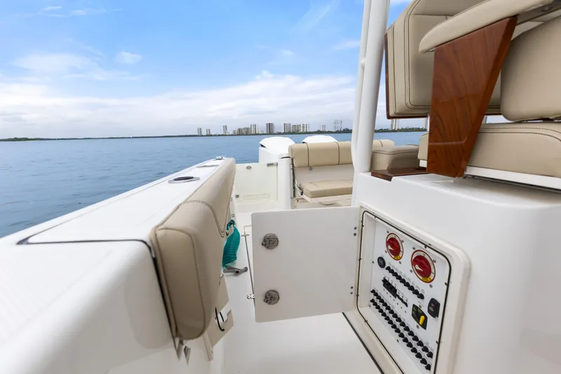 Little Perspective Yacht Photos Pics 2019 Pursuit S 288 Sport boat interior with control panel, beige seating, and ocean view.