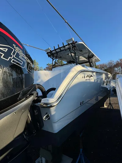  Yacht Photos Pics 2022 Invincible 40 Catamaran with powerful outboard engine, docked under clear blue sky.