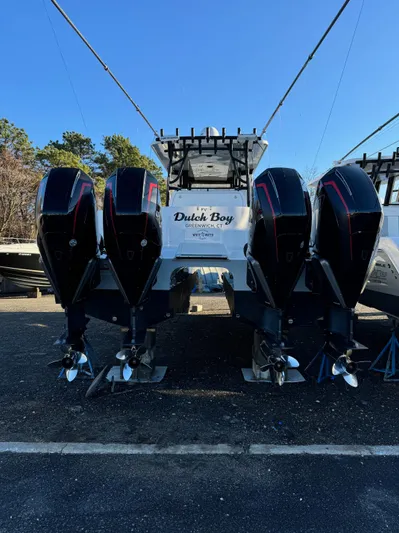  Yacht Photos Pics 2022 Invincible 40 Catamaran with four powerful outboard engines, docked outdoors.