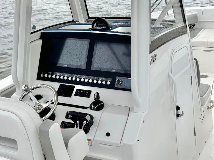  Yacht Photos Pics 2023 Regulator 28 boat dashboard with dual screens and steering wheel.