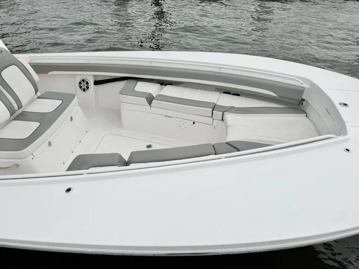  Yacht Photos Pics 2023 Regulator 28 boat interior with cushioned seating and storage, on calm water.