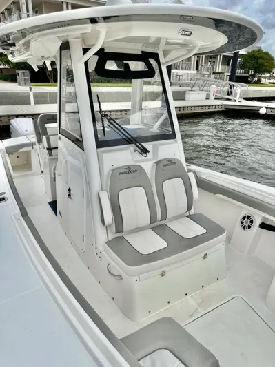  Yacht Photos Pics 2023 Regulator 28 boat with dual seats and modern console design at a marina.