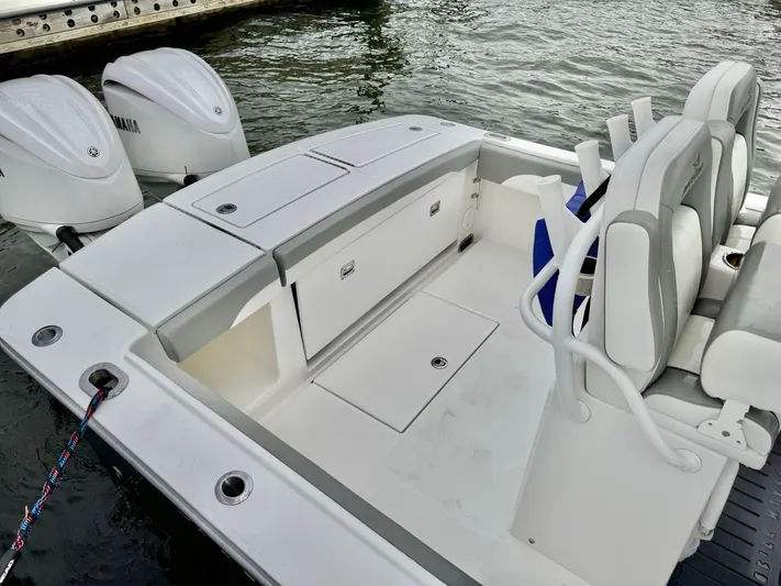  Yacht Photos Pics 2023 Regulator 28 boat with dual engines, spacious seating, and storage, docked by the water.