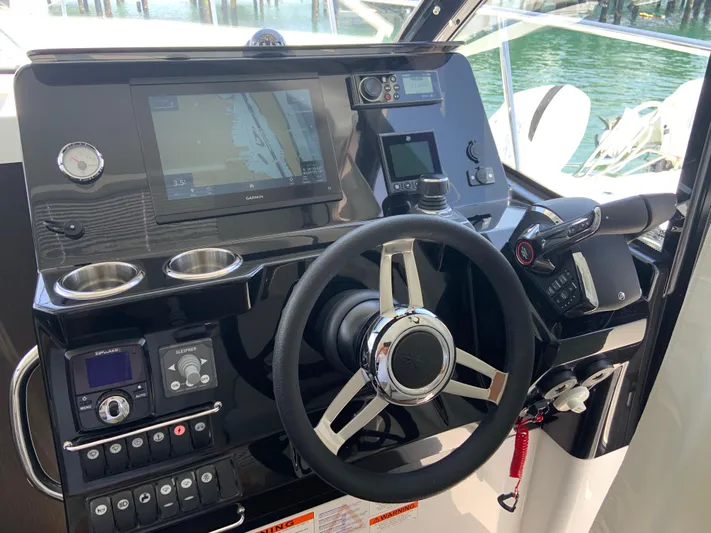 Yacht Photos Pics 2025 Jeanneau NC 1095 Coupe helm with navigation controls and steering wheel.