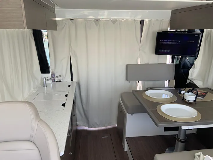  Yacht Photos Pics Interior of 2025 Jeanneau NC 1095 Coupe with dining area and kitchenette.