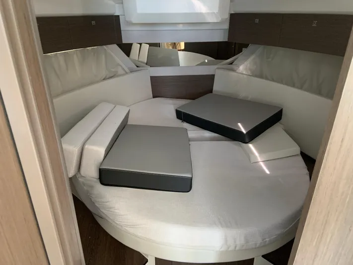  Yacht Photos Pics Interior cabin of 2025 Jeanneau NC 1095 Coupe with circular bed and cushions.