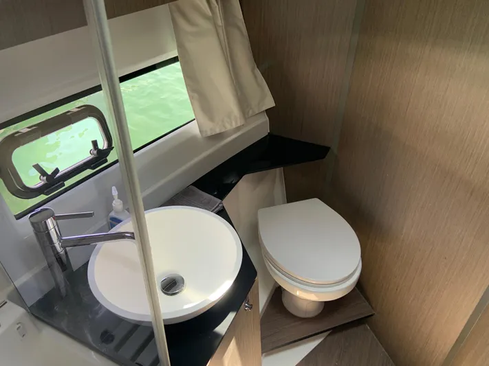  Yacht Photos Pics 2025 Jeanneau NC 1095 Coupe bathroom with modern sink, toilet, and window view.