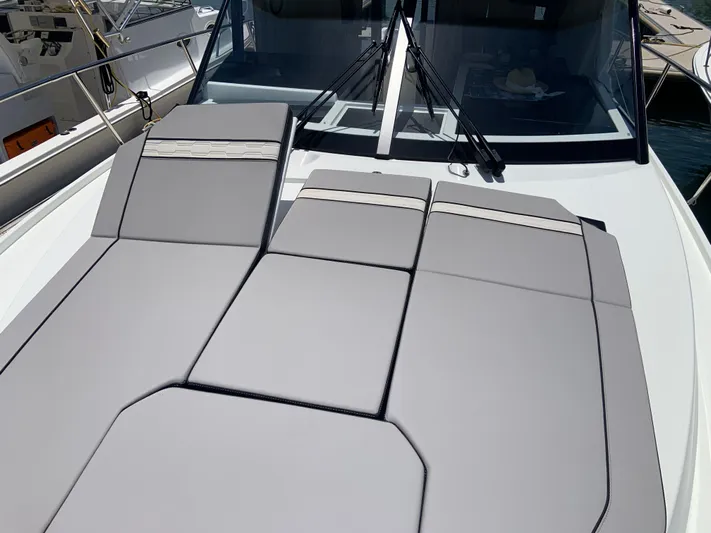  Yacht Photos Pics 2025 Jeanneau NC 1095 Coupe boat with sleek sunbathing cushions on deck.