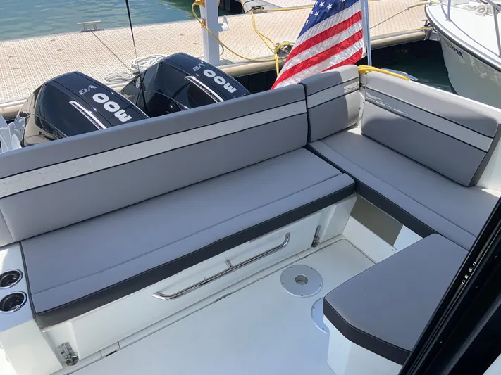  Yacht Photos Pics 2025 Jeanneau NC 1095 Coupe boat with gray seating and American flag at dock.