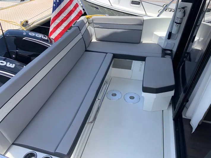  Yacht Photos Pics 2025 Jeanneau NC 1095 Coupe boat interior with gray seating and American flag.