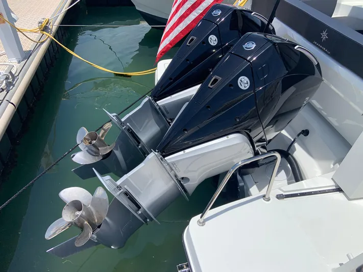 Yacht Photos Pics 2025 Jeanneau NC 1095 Coupe with dual outboard motors docked in marina.