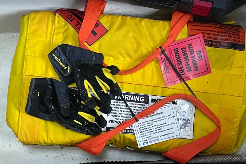 Maddie Janes Yacht Photos Pics Safety equipment on a 2009 Sea Ray 40 Sundancer, featuring a yellow life raft and gloves.