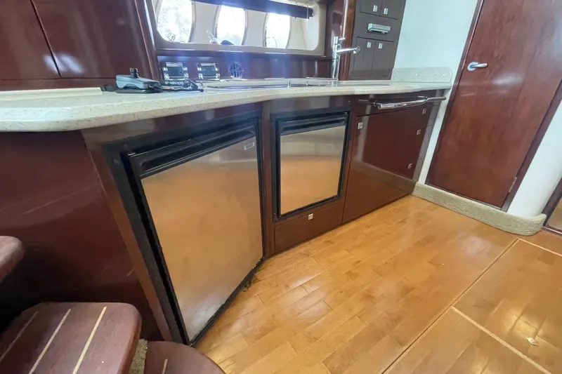 Maddie Janes Yacht Photos Pics 2009 Sea Ray 40 Sundancer kitchen with wood flooring and stainless steel appliances.
