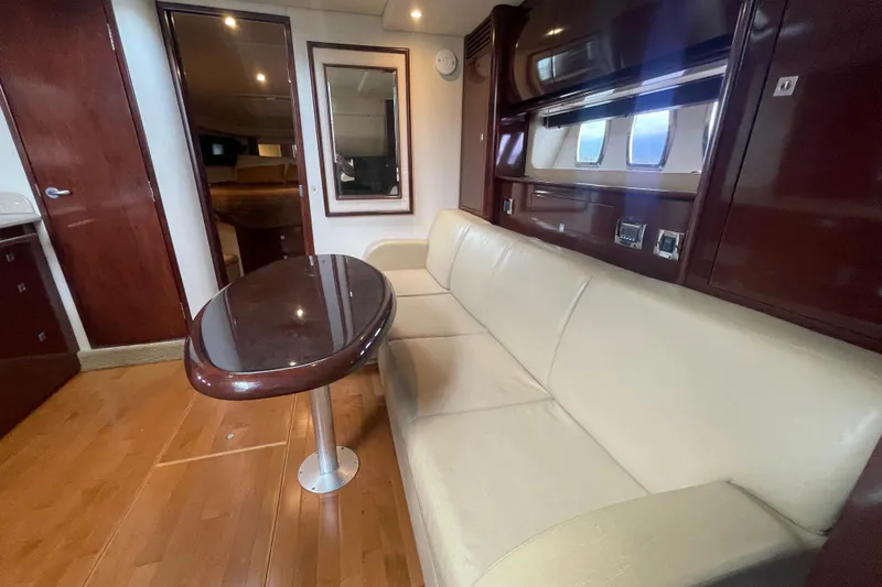 Maddie Janes Yacht Photos Pics Interior of 2009 Sea Ray 40 Sundancer yacht with beige sofa and wooden table.