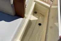2023 Invictus GT280 boat storage compartment with open lid and cushioned seating.