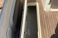 2023 Invictus GT280 boat with open storage compartment on teak deck.